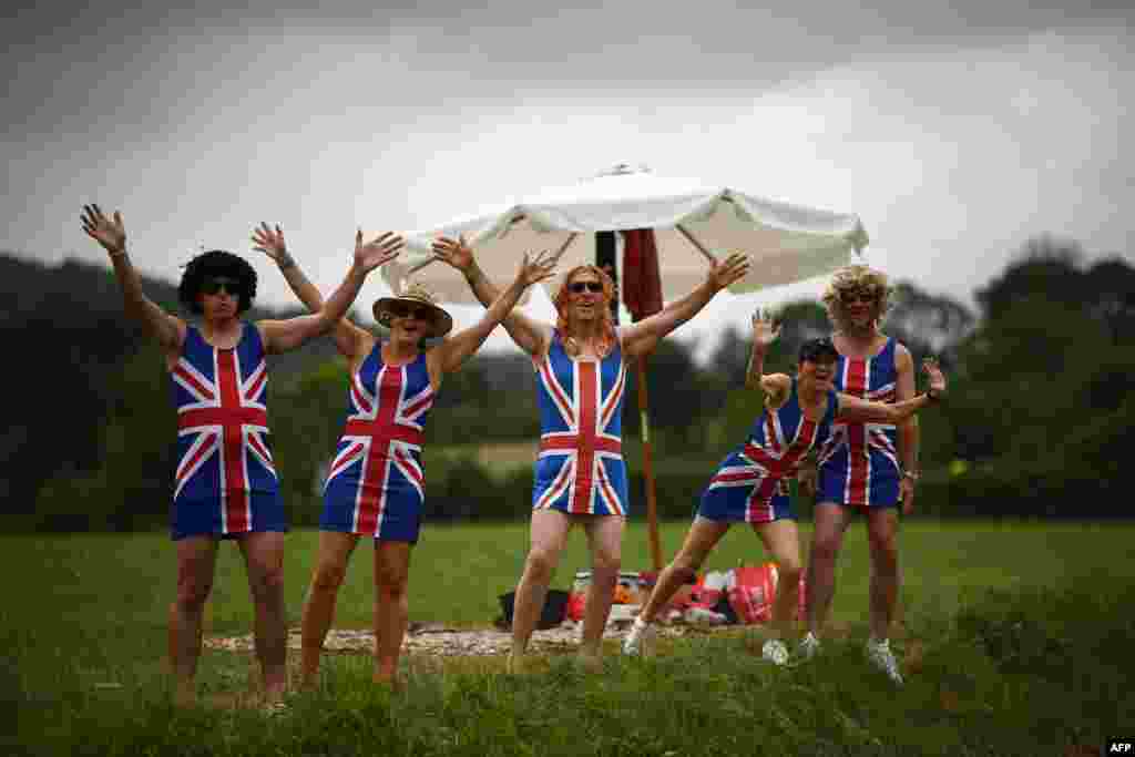 Cycling enthusiasts wearing dresses with the Union Jack gesture on the roadside as they wait for riders in Foix Prat d'Albis, France, during the fifteen stage of the 106th edition of the Tour de France cycling race between Limoux and Foix Prat d'Albis.