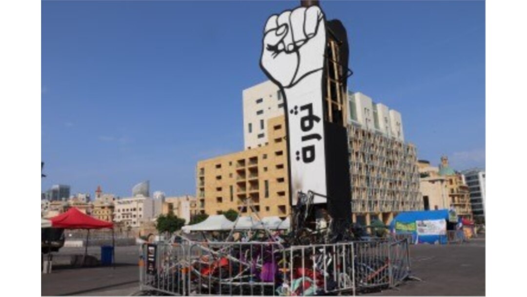 This fist statue in Martyr's Square says "Revolution." Below it are the remnants of tents burned by counterprotesters in the early days of the demonstrations, pictured in Beirut on Nov. 14, 2019. (Heather Murdock/VOA)