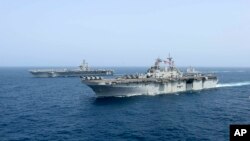 El barco de asalto anfibio Kearsage de la armada de EE.UU. navega frente al portaaviones USS Abraham Lincoln en el Mar de Arabia. Foto Armada EE.UU.