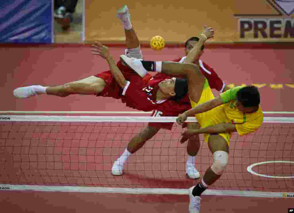Thailand's Supachai Maneenat, left, returns a shot from Myanmar's Aung Pyah Tun, right, during their men's sepaktakraw match at the Southeast Asian (SEA) Games in Naypyitaw, Burma.