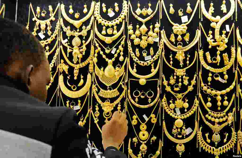 A man arranges gold jewels on a display inside a jewellery shop at Wuse market in Abuja, Nigeria.