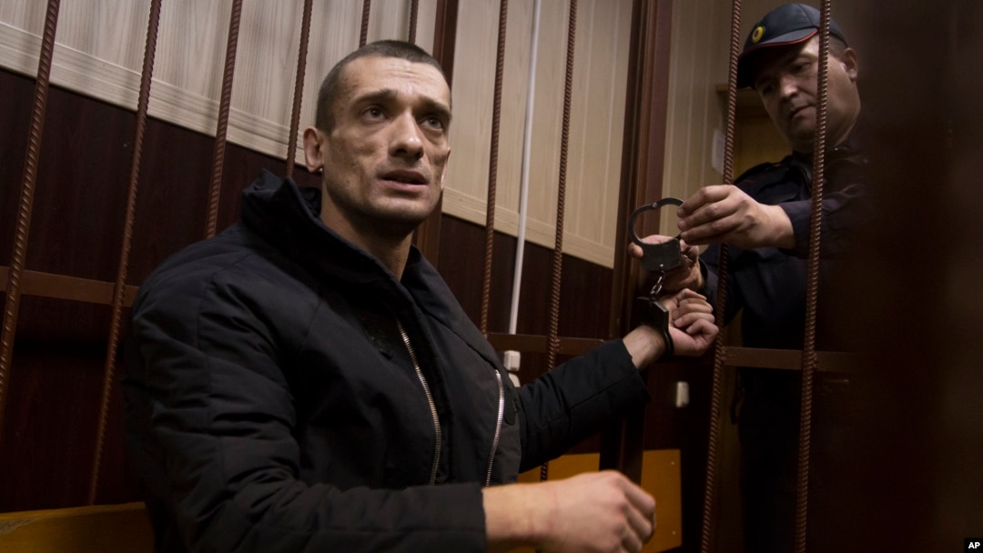 FILE - Russian artist Petr Pavlensky speaks to journalists as he sits in a cage in courtroom in Moscow, March 31, 2016. The artist, known for his political art performances, is one of three winners of the Human Rights Foundation's 2016 Vaclav Havel Prize for Creative Dissent.