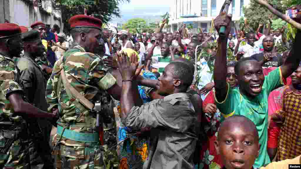 Nkurunziza encontra-se na Tanzânia para participar numa cimeira de cinco países da África Oriental convocada para analisar a vaga de violência no Burundi. Enquanto isso, nas ruas da capital, Bujumbura, dezenas de milhares de pessoas, incluindo muitos militares, estão a celebrar o aparente golpe de estado. Burundi, Bujumbura, Maio 13, 2015